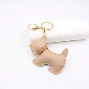 Macro detail of tan leather Schnauzer keychain with gold metal clasp and collar accessory