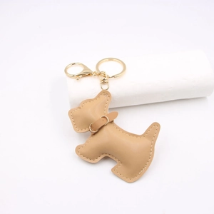 Close-up of light brown leather dog keychain with cream stitching and gold lobster clasp