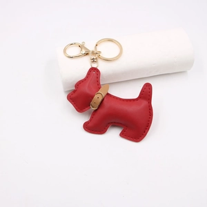 Close-up of red leather schnauzer dog keychain charm with detailed stitching and gold hook