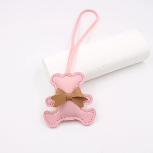 Close-up of pink PU leather bear charm with brown bowknot and matching long lanyard