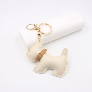 Detailed close-up of beige leather schnauzer dog keychain with premium stitching and gold ring