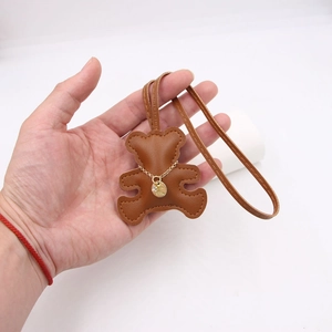Brown leather bear keychain with golden chain and diamond pendant on a long lanyard