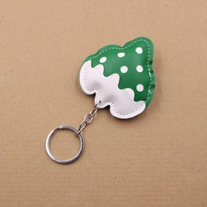 Detail of Christmas tree PU leather keychain with green white polka dots and metal ring
