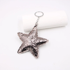 Detail of star-shaped bronze faux leather keychain with textured snakeskin pattern