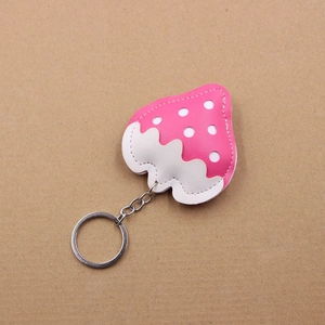 Detail shot of strawberry shaped keychain with pink polka dots and white stitching