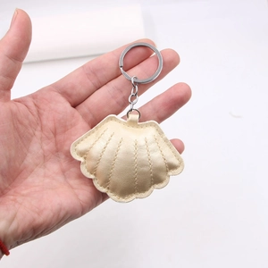 Close-up of pearlized leather shell keychain with metallic finish and silver ring