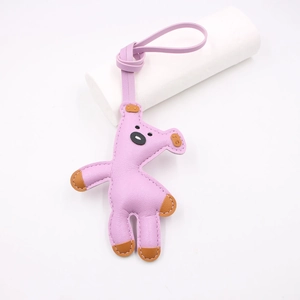 Close-up of purple cartoon bear leather charm with litchi texture and hanging strap