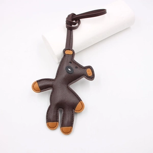 Detailed close-up of brown leather giraffe pendant with visible hand-stitched textures