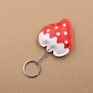 Close-up of strawberry faux leather keychain with white polka dots and silver metal ring