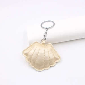 Stereo seashell leather keychain in champagne gold with silver ring and stitch texture
