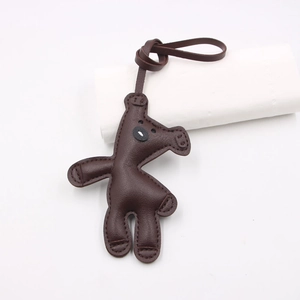 Detailed close-up of dark brown leather horse bag charm with handcrafted stitching