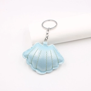 Light blue faux leather seashell keychain with metallic finish and silver ring charm
