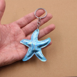 Holographic blue starfish keychain pendant with silver metal ring and white stitching