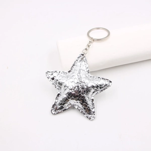 Close-up of silver star leather keychain with crackle texture and fine edge stitching