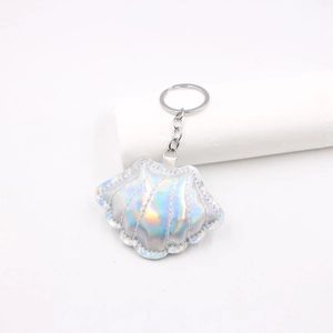 Macro detail of laser iridescent shell keychain with silver metal ring and stitch texture