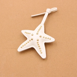 Pendentif étoile de mer en simili cuir blanc avec rivets dorés et lanière assortie