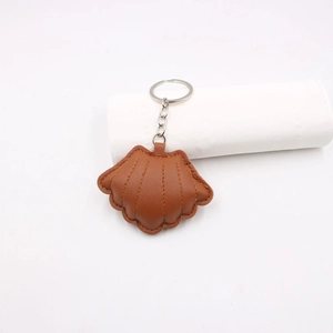 Macro detail of caramel brown shell leather keychain with lychee grain and stitching