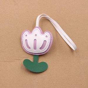 Detail view of purple and white leather tulip charm with delicate hollowed-out petal patterns