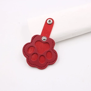 Detail view of red cat paw leather pet hair collector pouch with silver snap buttons