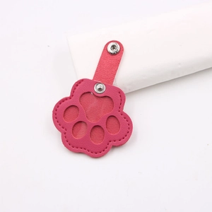 Close-up of pink paw-shaped leather pet hair collector keychain with snap fastener
