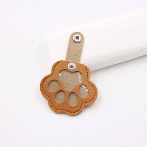 Portable brown paw-shaped pet hair collector keychain with clear PVC window for photos
