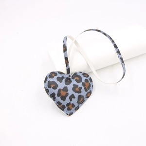 Detailed view of the blue leopard print heart leather charm with fine edge stitching detail
