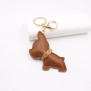Brown leather French Bulldog keychain pendant with golden metal hardware on white background