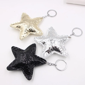 Star-shaped leather keychains in gold, silver, and black with textured snakeskin finish
