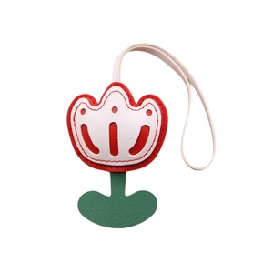 Red tulip leather bag charm with white stitching and green leaf detail on white background