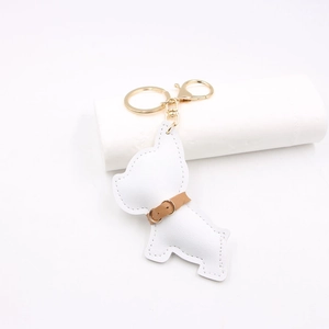 Detailed close-up of white leather bulldog keychain with gold metal clasp and stitching