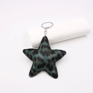 Macro detail of star-shaped keychain with green leopard print leather and metal ring