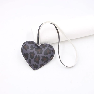 Close-up of heart-shaped leopard print faux leather bag charm with neat stitching details