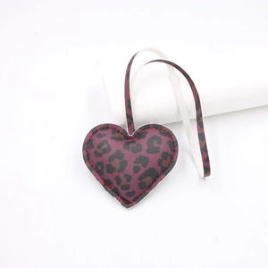 Detailed view of burgundy leopard print heart charm with high-quality stitching