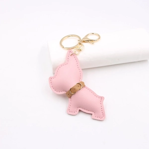 Detail of pink faux leather French Bulldog keychain with gold ring and fine stitching