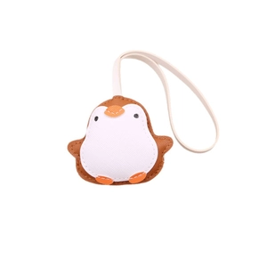 Cute penguin bag charm made of textured brown leather with a white lanyard on a white background