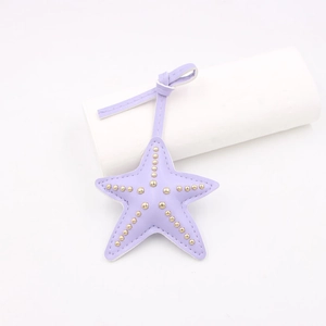 Détail d'un pendentif étoile de mer en similicuir violet avec clous dorés et coutures