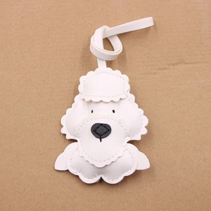 Detail of white leather teddy dog bag charm with stitching and black embroidery