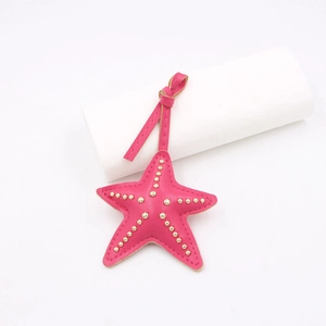 Vue détaillée du pendentif étoile de mer en cuir rose avec clous dorés et coutures