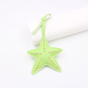 Bijou de sac étoile de mer en cuir vert fluo avec clous dorés et lanière assortie