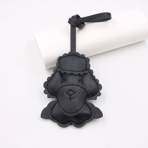 Close-up of black leather poodle bag charm showing fine stitching and embossed facial details