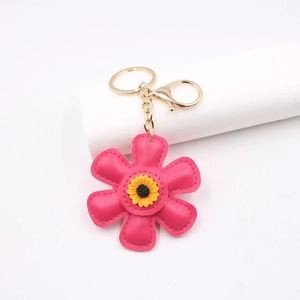 Detailed view of pink leather sunflower keychain with gold hardware and fine stitching