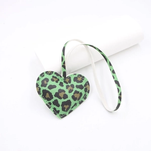 Detail of leopard print heart pendant with visible stitching on litchi leather texture
