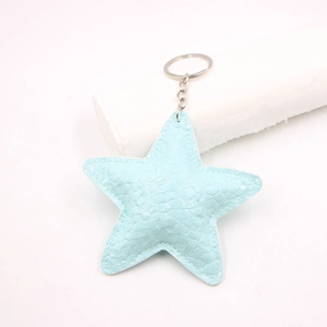 Close-up of a light blue pleated leather star keychain with a metallic silver ring