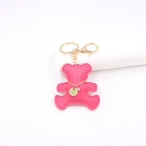 Close-up of rose pink faux leather bear pendant with gold keychain and lobster clasp