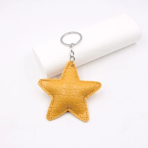 Yellow crocodile embossed leather star keychain with silver metal ring and fine stitching