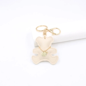 Detailed view of beige leather bear keychain with golden clasp and fine stitching