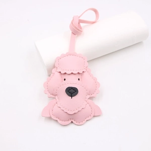 Detail of a pink leather poodle bag charm with precise stitching and long strap