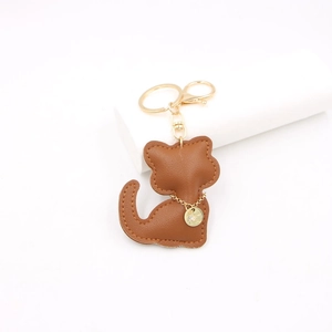 Brown leather cute cat keychain with gold chain and lobster clasp on white pedestal