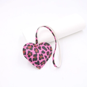 Detail of pink leopard print heart leather charm with black stitching and matching lanyard