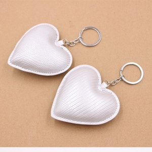 Porte-clés cœur en cuir embossé lézard, coloris argent et blanc, sur fond de papier kraft